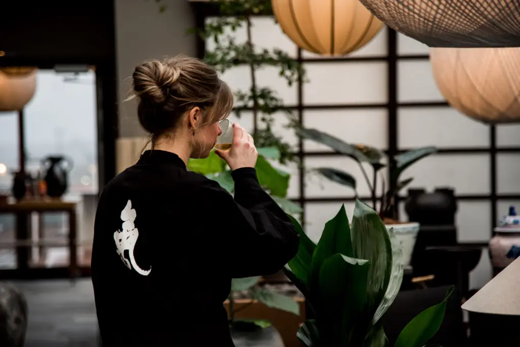 Kvinna dricker te i orangeriet på Asia Spa